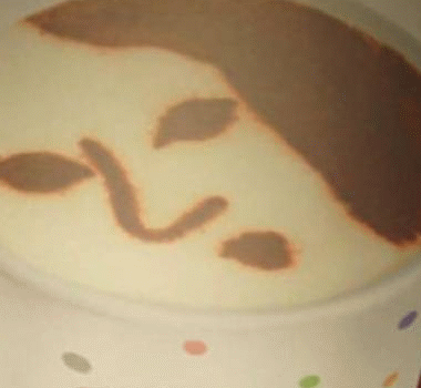 Una mquina expende caf con caras humanas dibujadas en la espuma