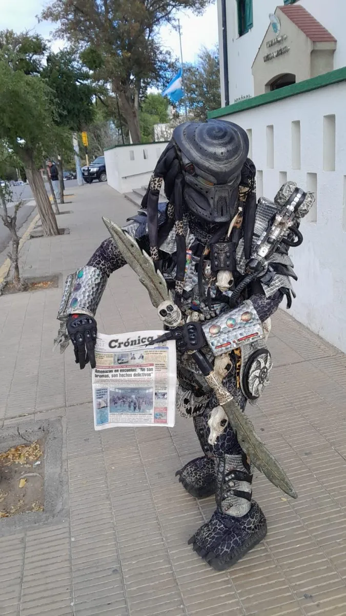 Edgar Martel vestido de Depredador, captando la atención en una ciudad