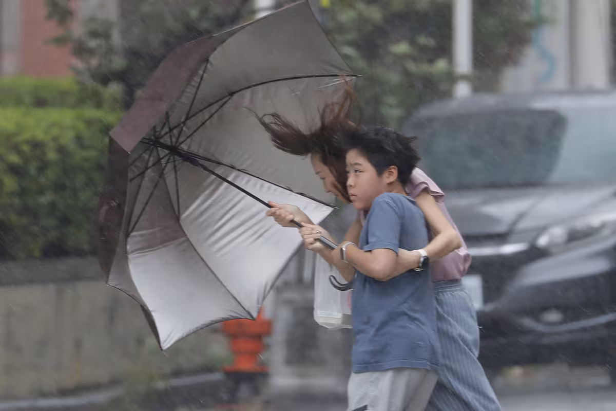 una-mujer-y-un-nino-avanzan-entre-la-lluvia-C4JL3APPVZDRZPIRBPILWAGCAQ.jpg