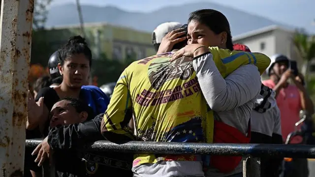 Dos personas se abrazan llorando en Catia la Mar al día siguiente del doblete sísmico del 24 de junio en Venezuela